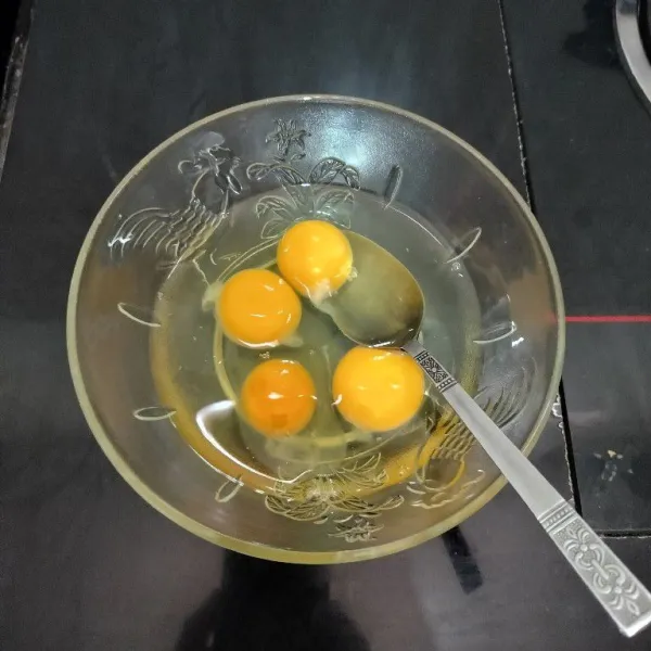Pecahkan telur, lalu masukkan ke dalam mangkuk.