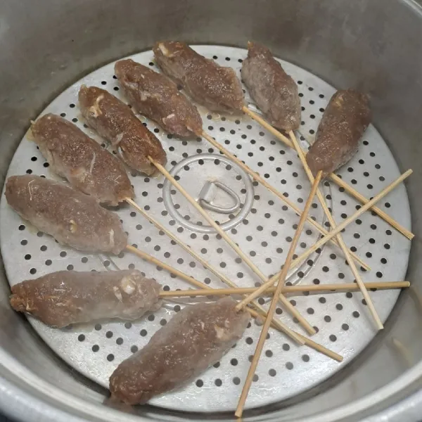 Panaskan dandang sampai air mendidih. Oles tatakan dandang dengan minyak goreng. Kukus sate selama 10 menit. Angkat dan sisihkan.