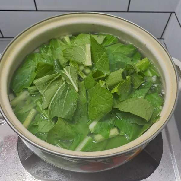 Masukkan sawi hijau. Masak sampai sayur matang lalu angkat dan sajikan.