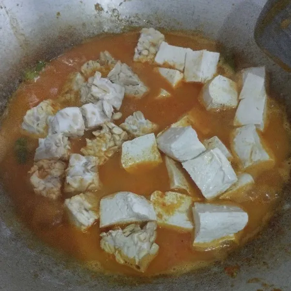 Masukkan tahu dan tempe yang sudah dipotong ke dalam rebusan bumbu. Aduk rata.
