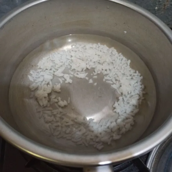 Masukkan nasi dan air ke panci. Masak