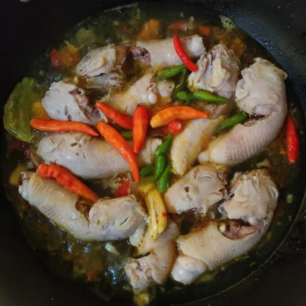 Masukkan kepala ayam dan cabe, aduk rata.
