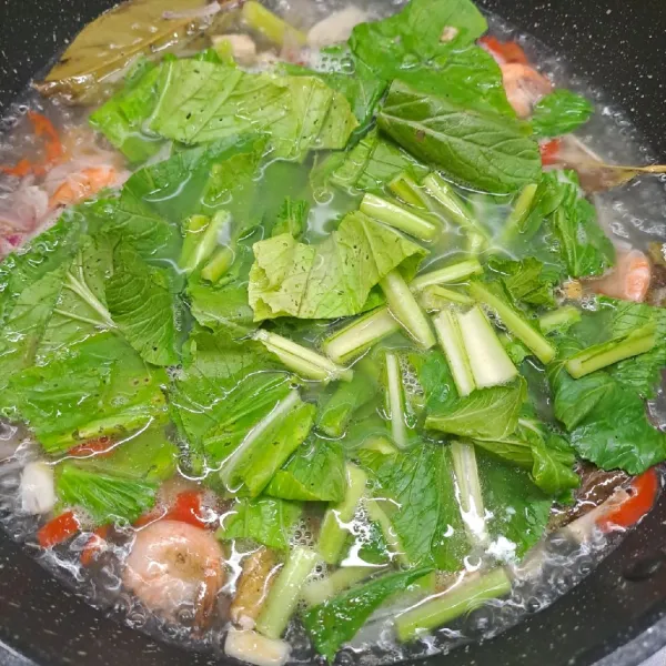 Masukkan krimer bubuk, kaldu jamur dan garam. Aduk rata sambil koreksi rasa sesuai selera. Masukkan sawi dan tahu goreng. Masak sampai sayur matang.