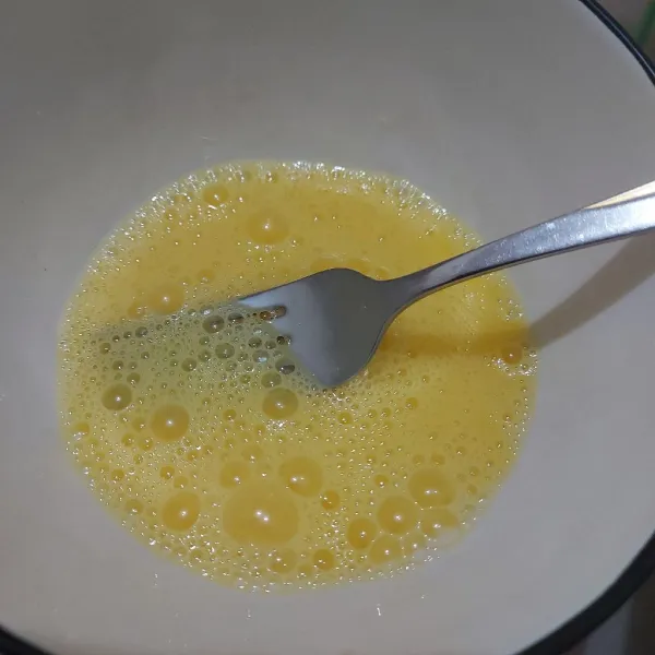 Pecahkan 2 butir telur, bubuhi garam dan merica bubuk secukupnya kemudian kocok hingga berbuih.