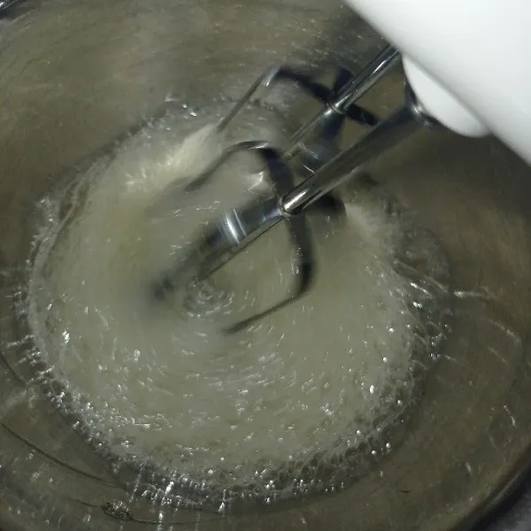 Mixer putih telur dengan kecepatan rendah, jika sudah mulai berbuih masukkan perasaan jeruk nipis dan garam. Kemudian mixer lagi, dan masukkan gula secara bertahap sampai 3 kali.