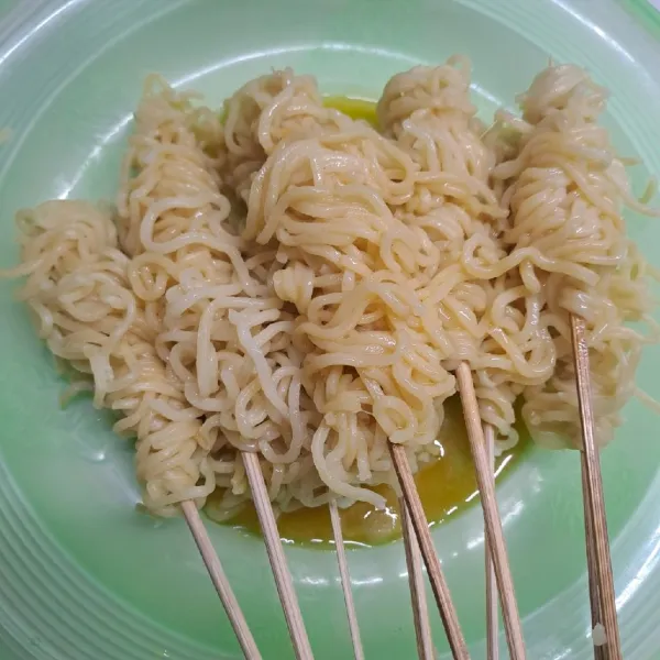 Tuang kocokan telur ke atas mi gulung sampai rata.