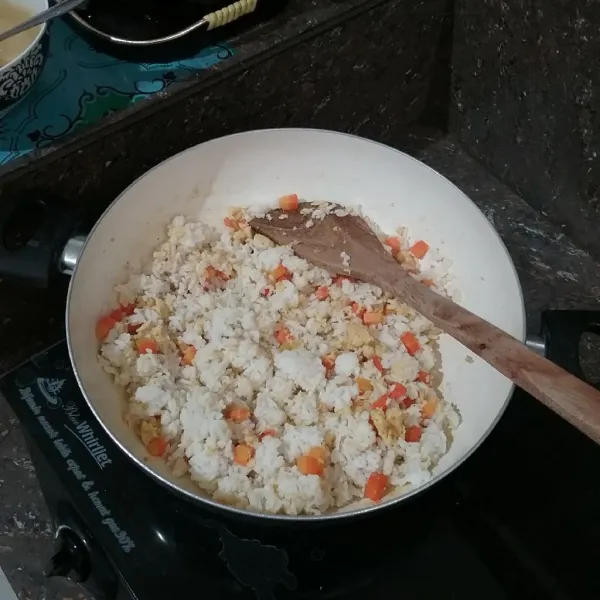 Masukkan nasi, beri kecap ikan, kaldu jamur, garam, dan lada bubuk, aduk hingga semua bahan tercampur rata, angkat, dan sajikan dengan sosis panggang.