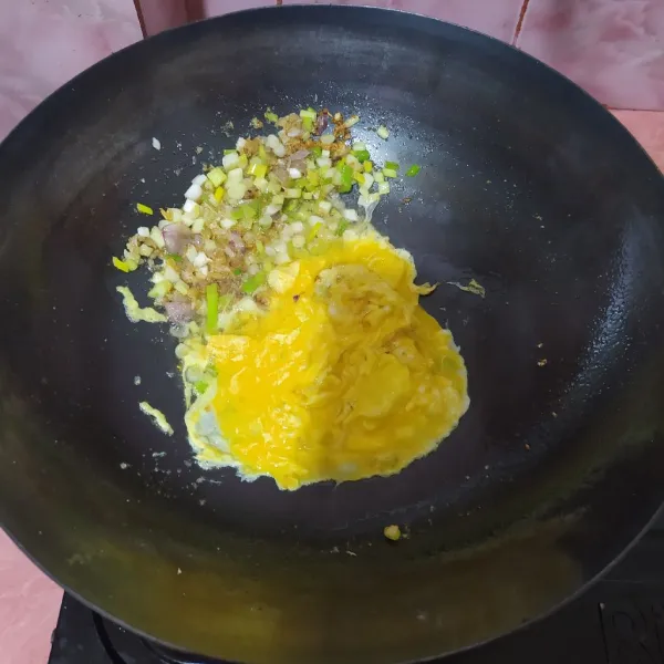 Sisihkan bumbu di pinggiran wajan. Tuang telur, buat orak-arik.