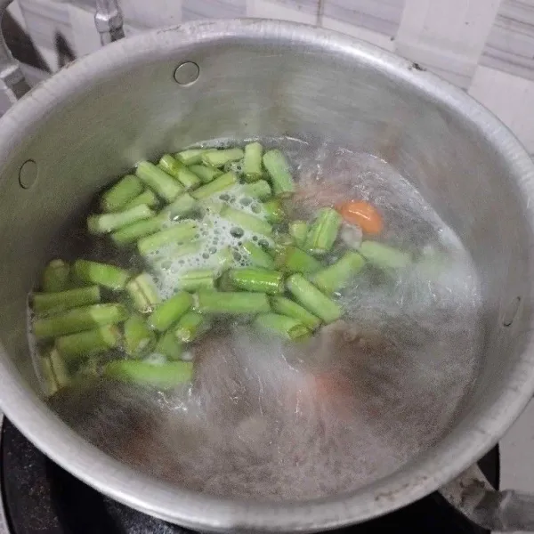 Setelah daging empuk, masukkan wortel dan buncis. Rebus hingga matang.