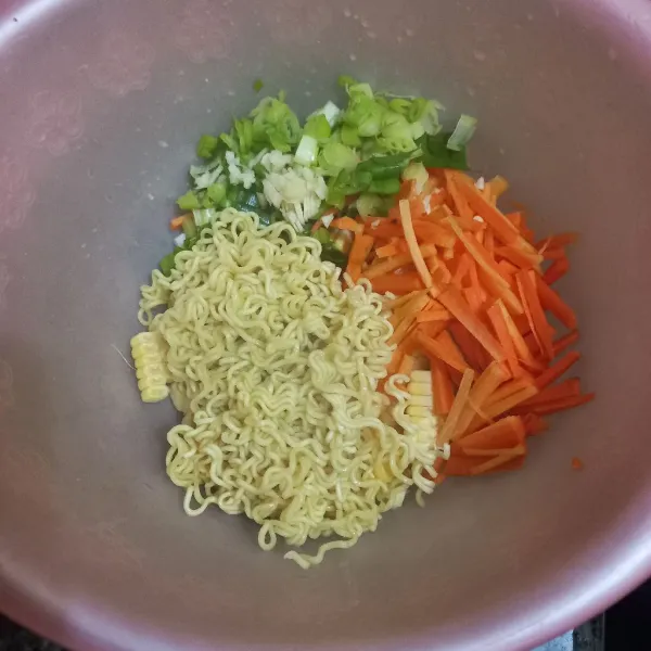 Tambahkan irisan korek wortel, bawang dain, bawang putih cincang dan mie