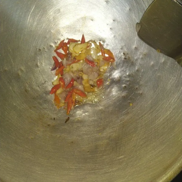 Panaskan minyak goreng, tumis bawang putih, lalu bawang merah dan cabe rawit hingga layu dan harum.