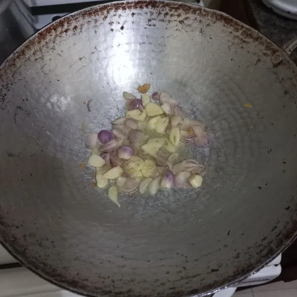 Tumis irisan bawang merah dan bawang putih hingga harum.