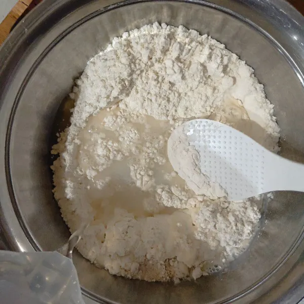 Dalam wadah, masukkan tepung terigu, ragi instan, gula pasir, minyak sayur, dan susu cair/air mineral, lalu aduk hingga rata
