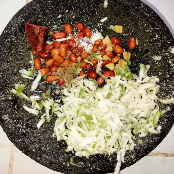 Masukkan setengah bagian bahan bumbu rujak, masukkan semua kecuali petis dan air asam (boleh langsung diuleg semua jika cobek berukuran besar).