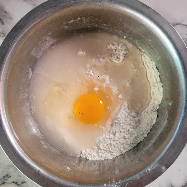 Tambahkan telur dan air kemudian aduk hingga rata.