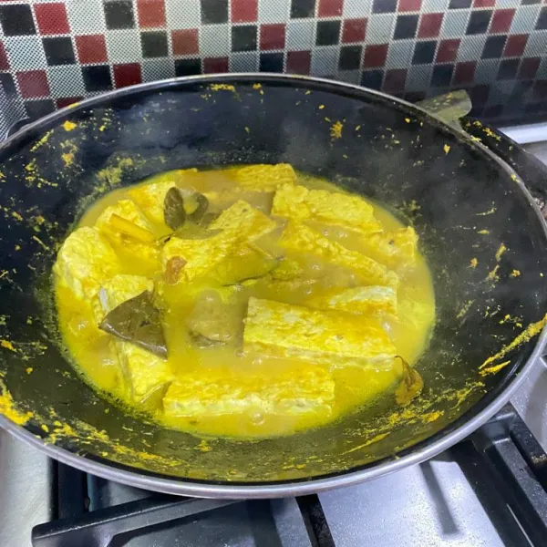 Siapkan wajan besar, masukkan tempe. Haluskan bumbu, masukkan kedalam wajan besar, balut tempe dengan bumbu halus, masukkan juga daun jeruk serai dan lengkuas. Aduk rata tambahkan air.