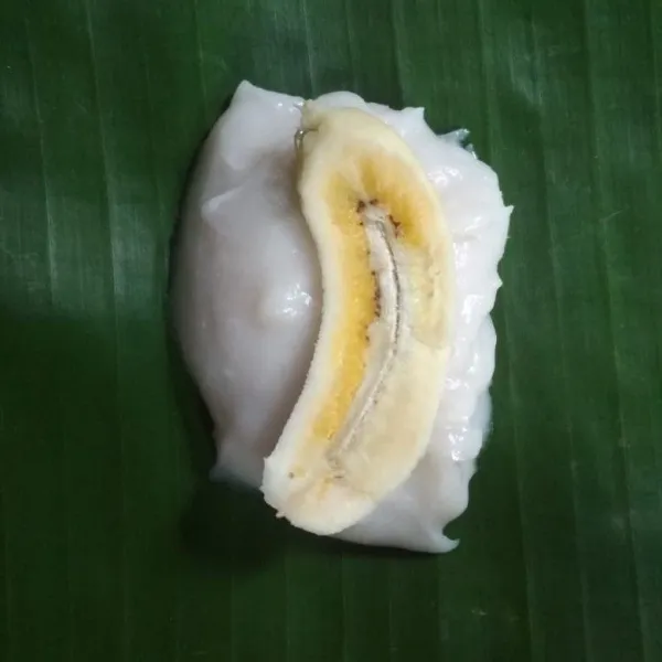 Siapkan daun pisang 2 lembar kemudian beri adonan dan beri irisan pisang, tutup dengan adonan lalu lipat.