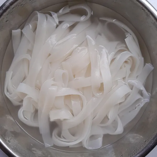 Didihkan 1 liter air dalam panci. Masukkan kwetiau dalam wadah, kemudian masukkan air mendidih, aduk hingga terendam. Tutup wadah dan diamkan selama 7 menit.