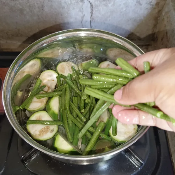 Bila sudah setengah matang, masukkan kacang panjang.