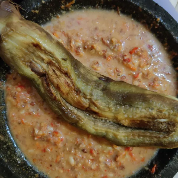 Masukkan terong, penyet menggunakan ulekan.