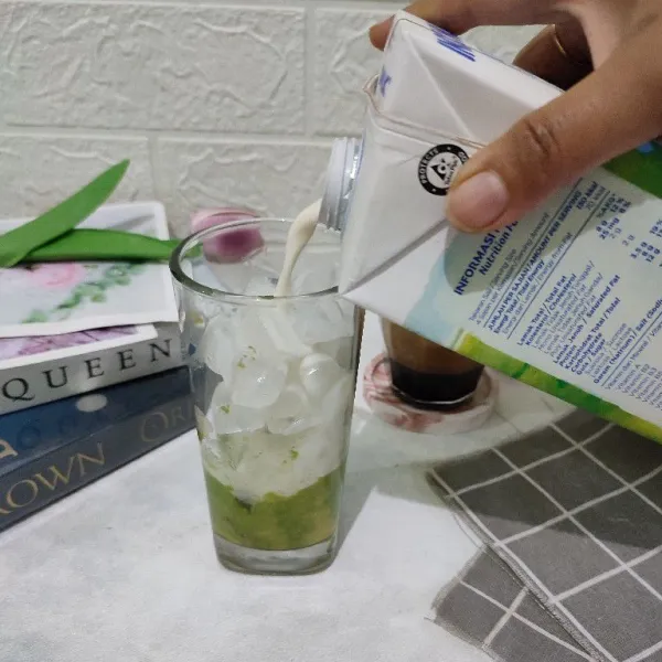 Tuang susu cair hingga gelas hampir penuh.