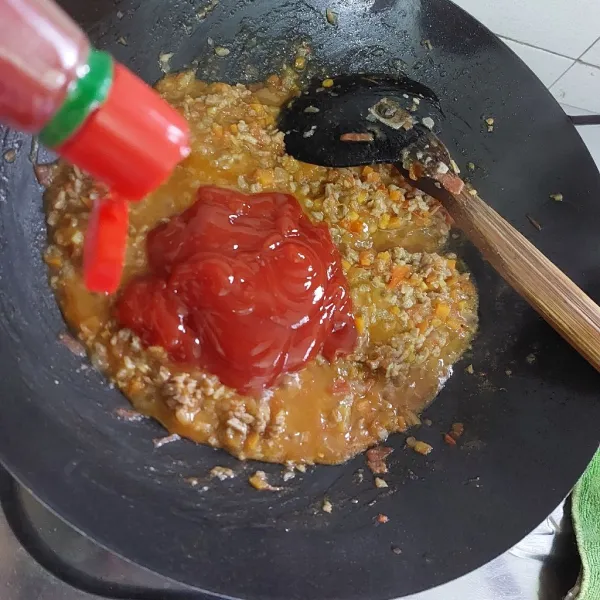 Tambahkan saos tomat, kemudian beri garam, lada bubuk, kaldu bubuk, dan gula pasir.