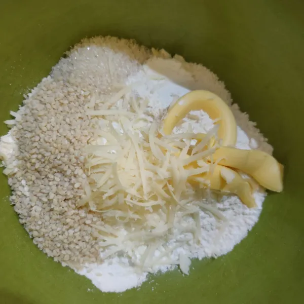 Campurkan tepung terigu, tepung beras, keju parut, wijen, gula pasir, margarin, dan baking powder, aduk rata.