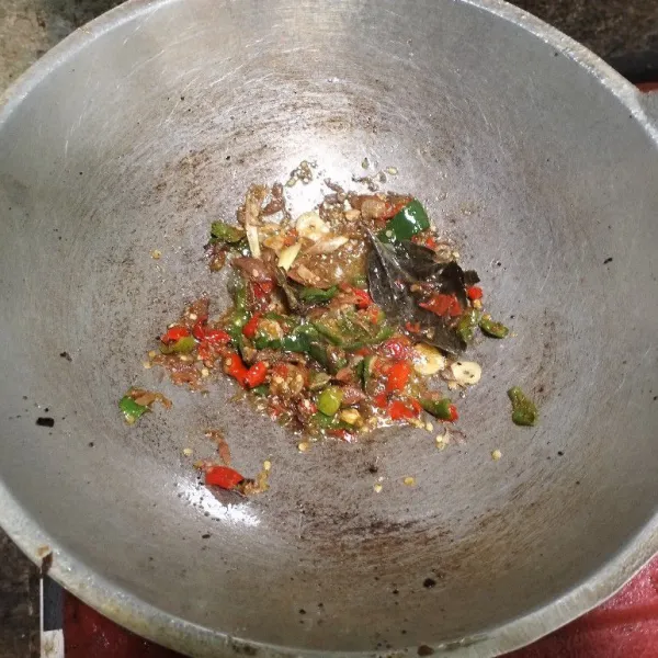 Masukkan bumbu cabai, daun salam dan serai. Masak hingga setengah kering.
