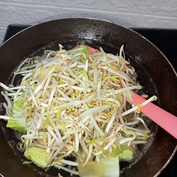 Masukkan sawi putih dan tauge. Tambahkan kecap kedelai, saus tiram, dan kaldu jamur lalu tuang air.