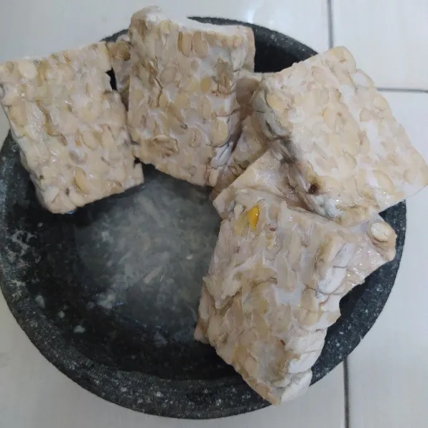 Potong tempe lalu marinasi.