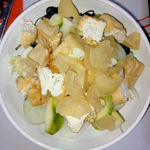 Dalam piring saji masukkan kangkung, tauge, potongan tahu, tempe, bengkoang, timun, nanas, kedondong dan kikil.