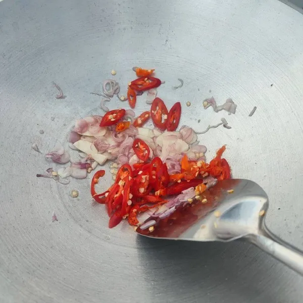 Tambahkan irisan cabe rawit dan cabe merah besar, tumis hingga layu.
