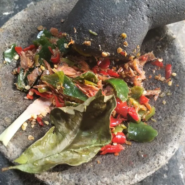 Tumbuk kasar cabai hijau dan cabai merah. Campurkan ikan asin dengan bumbu cabai, serai, dan daun salam.