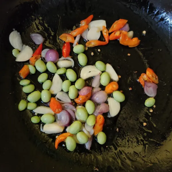 Masukkan edamame, tumis hingga setengah matang.