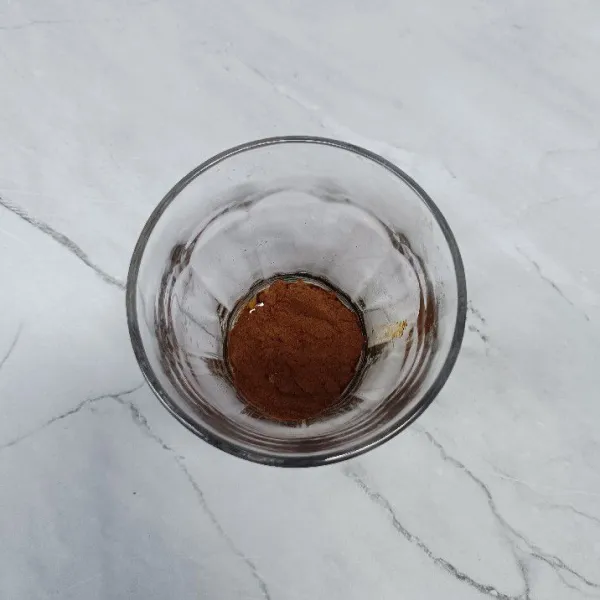 Siapkan gelas. Masukkan bubuk kopi hitam tanpa ampas.