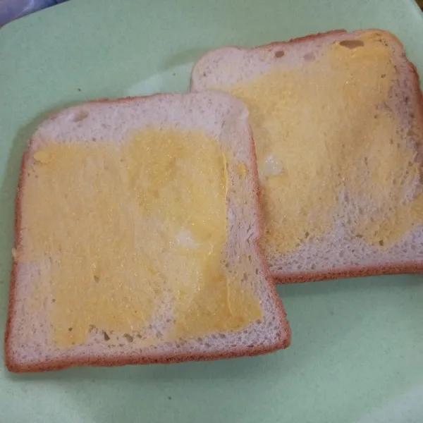 Olesi salah satu sisi roti dengan margarin secukupnya.