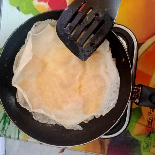 Tutup lagi dengan kulit lumpia. Beri minyak goreng di sekelilingnya.