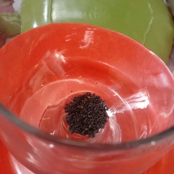 Kita mulai racik. Ini untuk 1 gelas, ya. Siapkan gelas saji. Masukkan ½ sdt biji selasih kering.