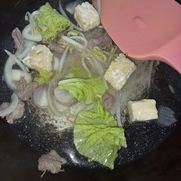 Tuang air masukkan tempe, tauge dan sawi, aduk rata masak hingga layu.