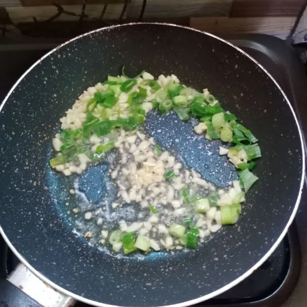 Panaskan sedikit minyak, tumis bawang putih dan daun bawang sampai harum.