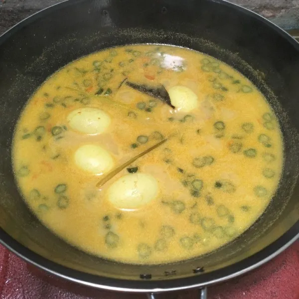 Tambahkan air, masak hingga mendidih dan empuk. Tambahkan santan, lalu masak sampai matang. Sajikan bersama bubur dan kerupuk