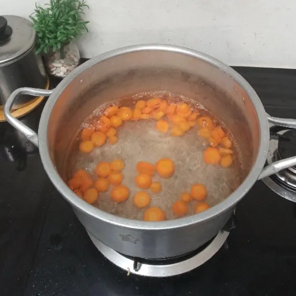 Didihkan air, masukkan wortel. Masak hingga wortel setengah matang.