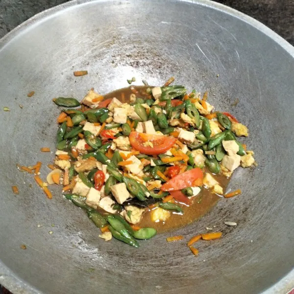 Tambahkan air, kecap manis, gula merah, dan tomat. Aduk rata semua bahan. Masak hingga matang seluruhnya.