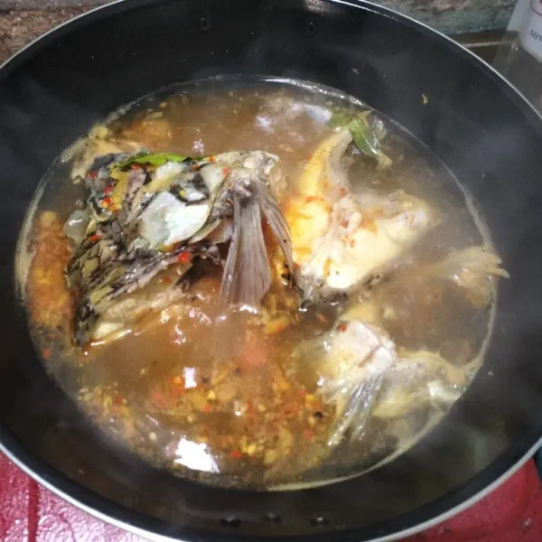 Tambahkan air baru, lalu pindahkan kepala ikan yang telah direbus tadi kedalam kuah pindang. Masak hingga mendidih, jangan terlalu banyak membalik ikan agar tidak hancur.