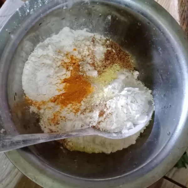 Dalam wadah masukkan terigu, tepung beras, ketumbar bubuk, kunyit bubuk, bawang putih bubuk, garam dan kaldu bubuk.