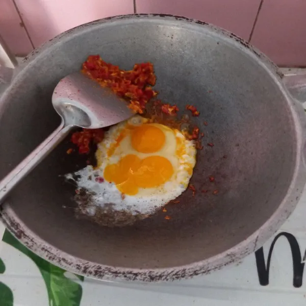 Ceplokan telur ditengah. Tunggu sebentar, kemudian orak arik hingga tercampur bersama bumbu halus.