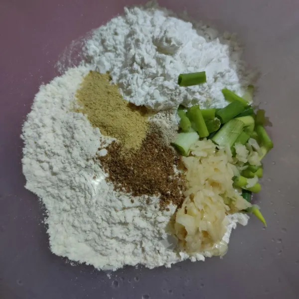Campurkan tepung terigu, tepung tapioka, daun bawang, bawang putih cincang, kaldu bubuk, lada bubuk, dan ketumbar bubuk. Aduk rata.