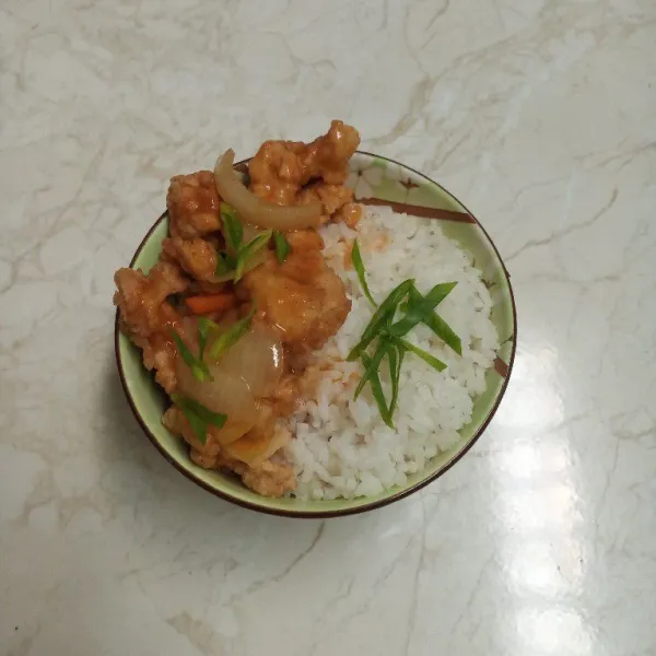 Siapkan nasi dalam mangkuk. Letakkan ayam, saus asam manis, dan daun bawang di atasnya