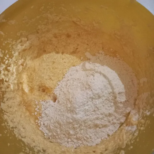 Campurkan tepung, baking powder, dan garam. Kemudian masukan adonan kering tadi ke adonan telur sedikit demi sedikit sambil diaduk dehgan mixer, memasukkannya bergantian dengan jus jeruk, diaduk hingga adonan berjejak.