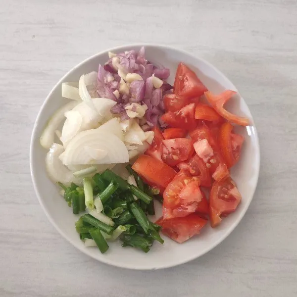 Iris bawang merah, bawang putih, bawang bombai, daun bawang, dan tomat potong dadu. Sisihkan.